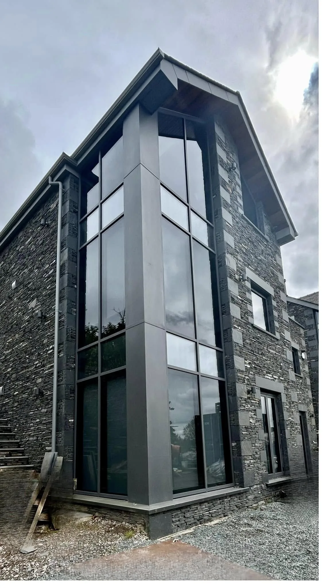 Tall structural glazing set into the corner of a stone building